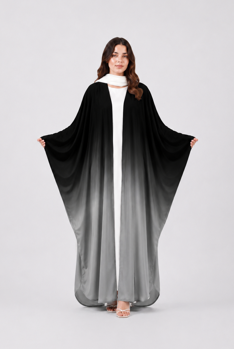 Woman wearing a black and gray gradient abaya on a white background