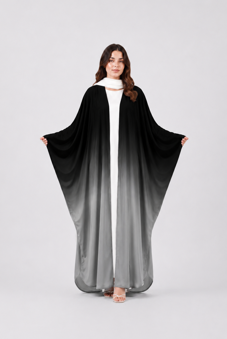 Woman wearing a black and gray gradient abaya on a white background