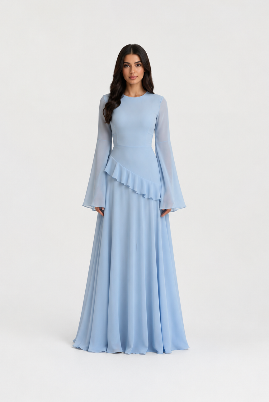 A woman modeling a light blue floor-length gown with long sheer bell sleeves, a round neckline, and a ruffled peplum waist, photographed against a plain light gray studio background.