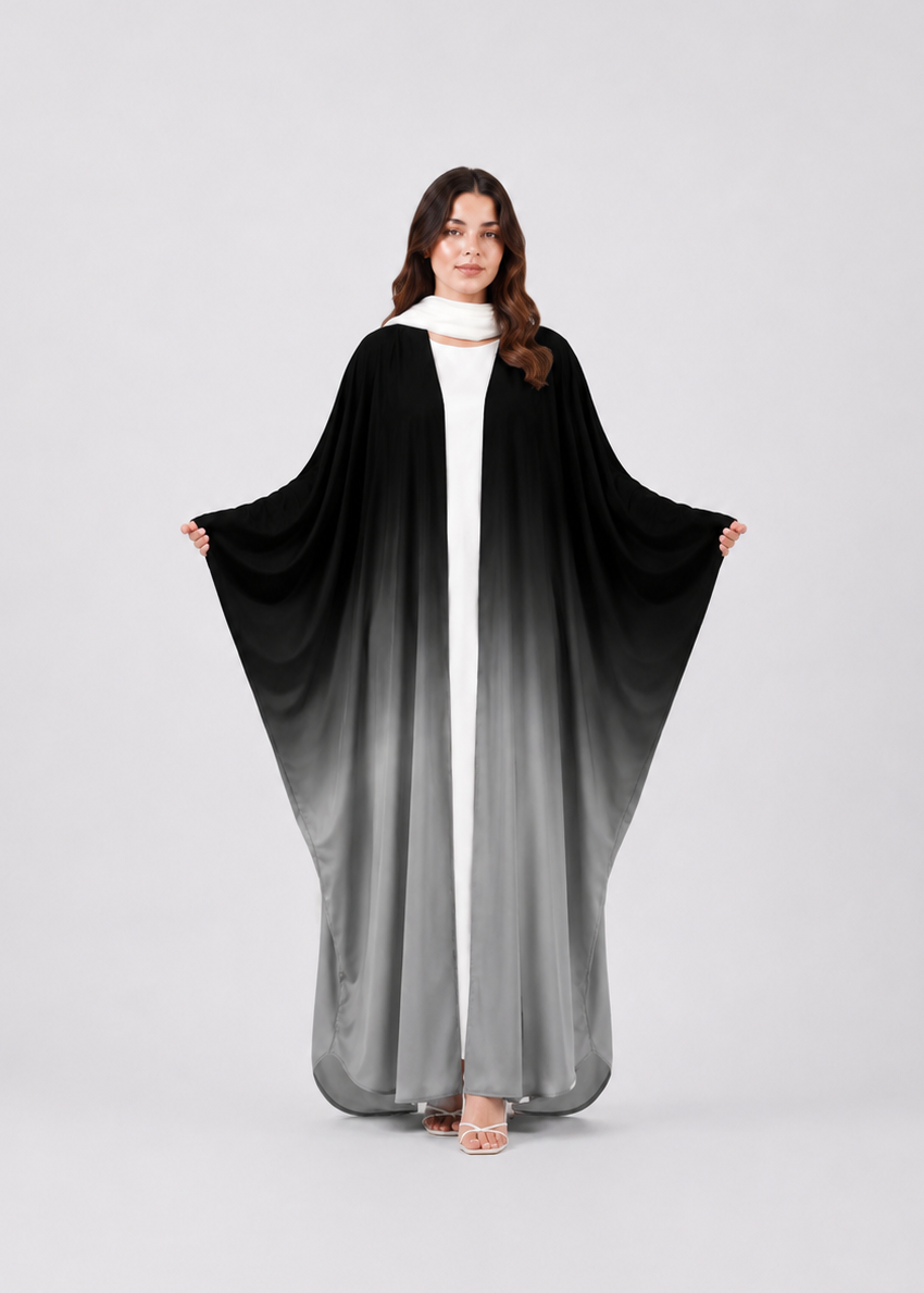 Woman wearing a black and gray gradient abaya on a white background