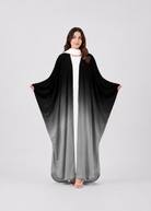 Woman wearing a black and gray gradient abaya on a white background