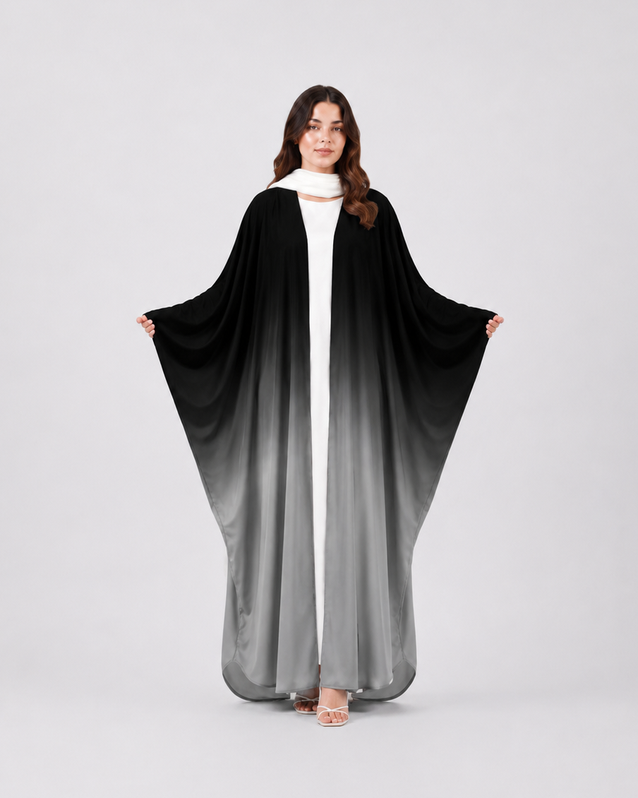 Woman wearing a black and gray gradient abaya on a white background