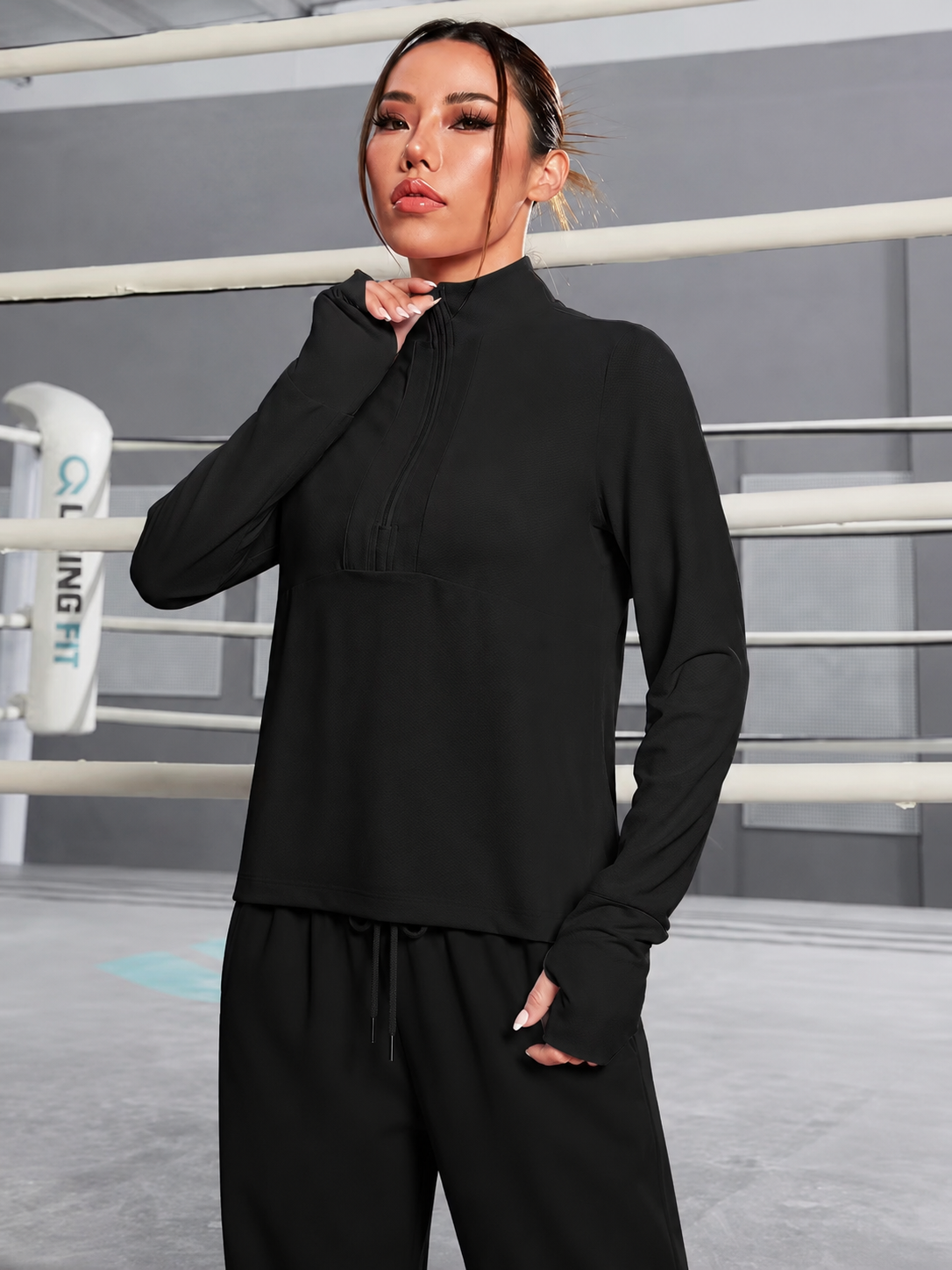 Person wearing a black outfit in a boxing ring setting
