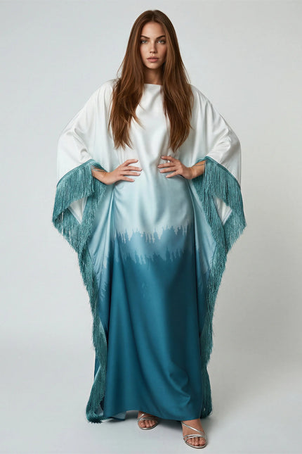 Woman wearing a white and blue gradient dress with a matching shawl on a plain background