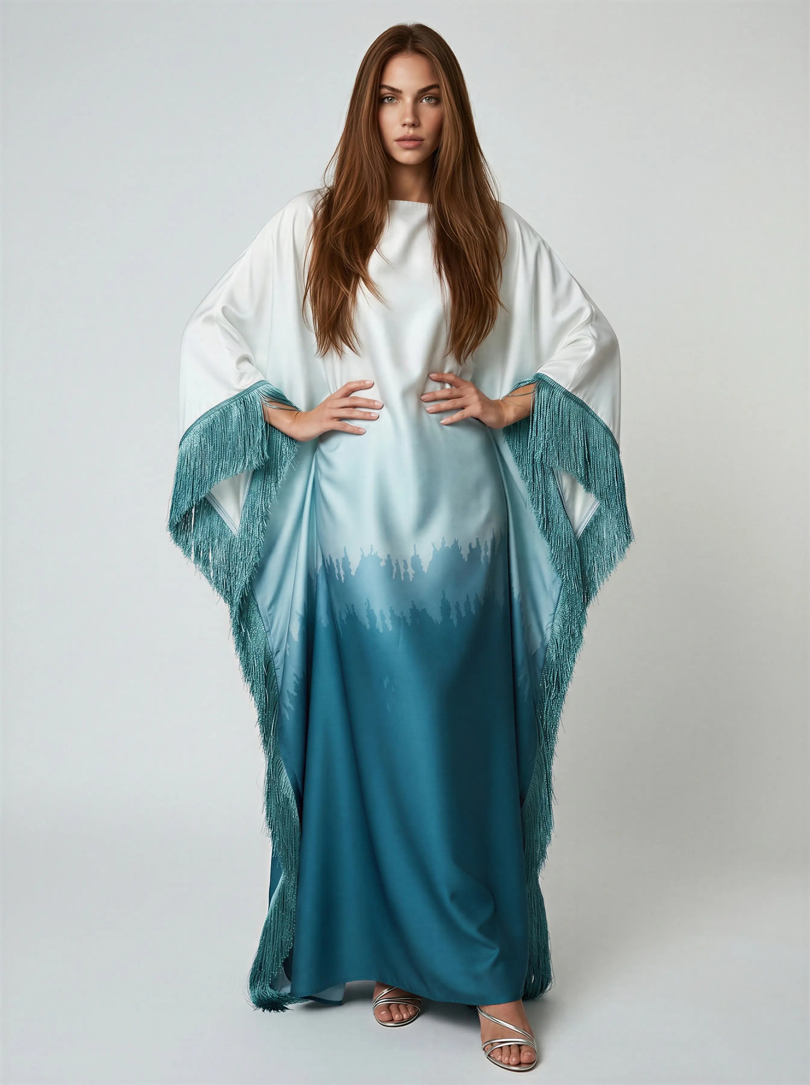 Woman wearing a white and blue gradient dress with a matching shawl on a plain background